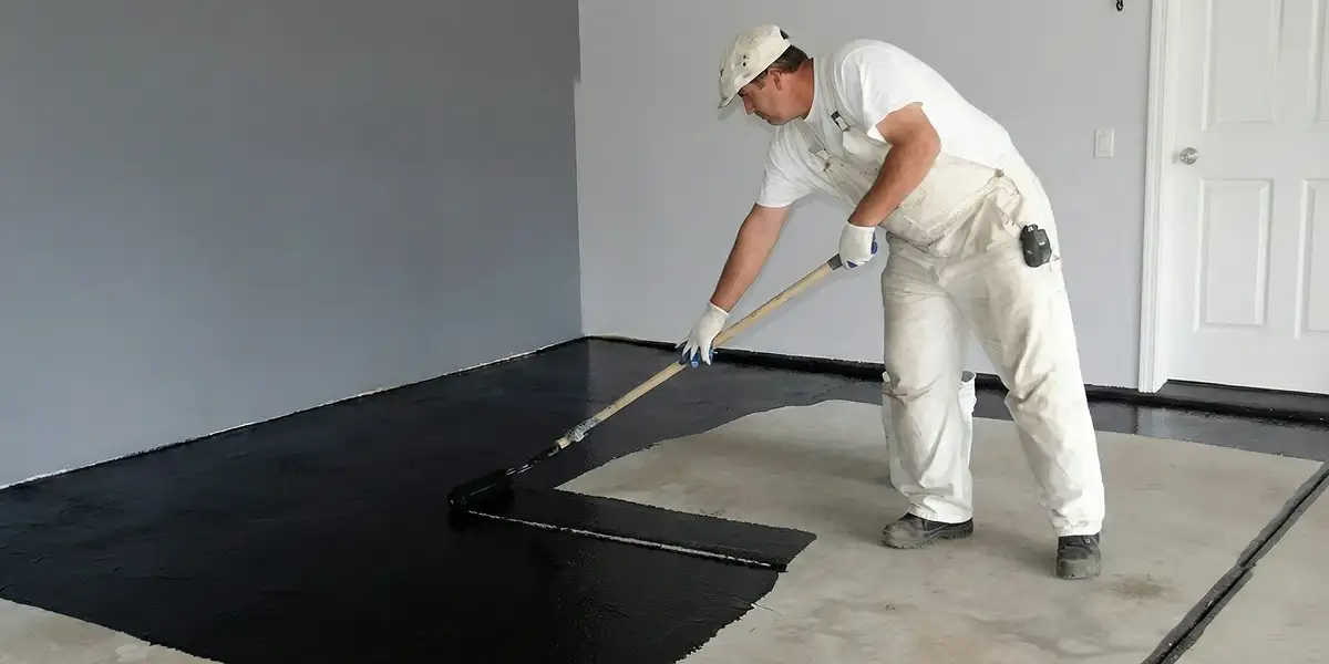 basement waterproofing professional applying waterproof coating to protect a basement floor in St Paul, MN